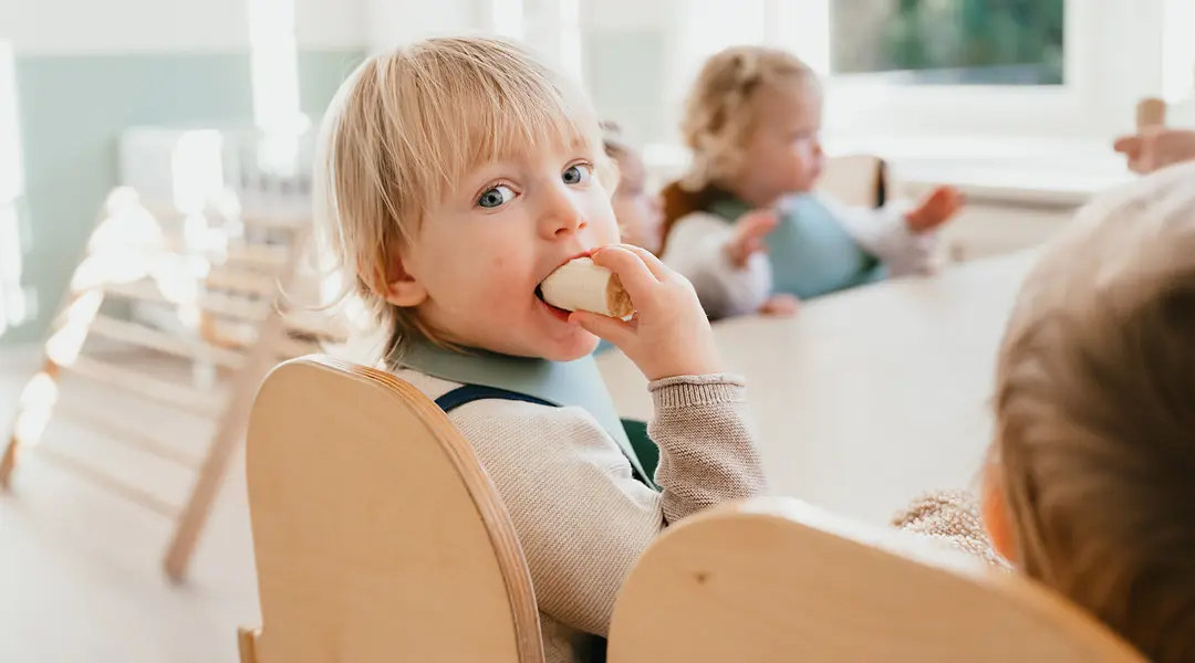 Peuter eet een banaan aan eenttafel