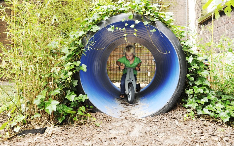 kind fietst door een kleine tunnel