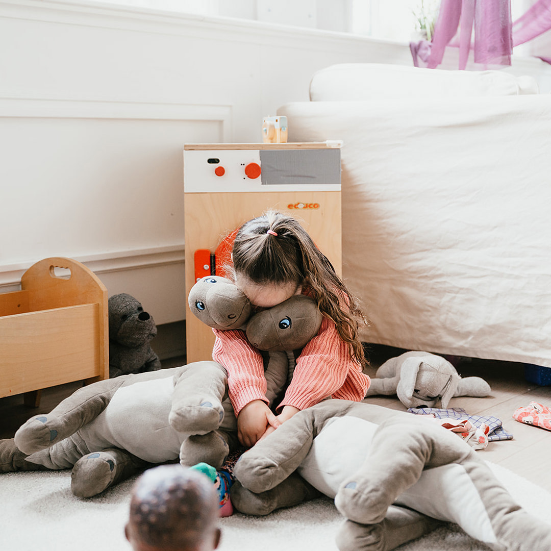 Verdrietig meisje verstopt zichzelf in knuffels