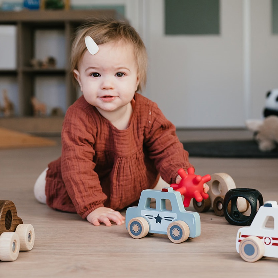 Meisje speelt met speelgoedauto's