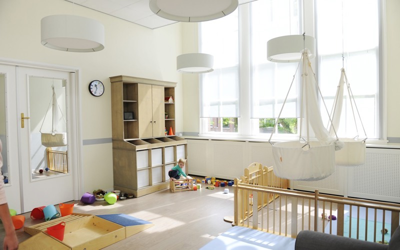 kind speelt met houten speelgoed op de babygroep