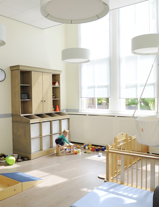 kind speelt met houten speelgoed op de babygroep