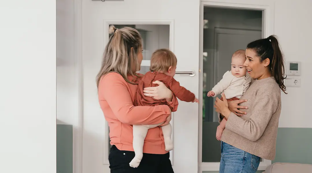 Twee vrouwen houden baby vast
