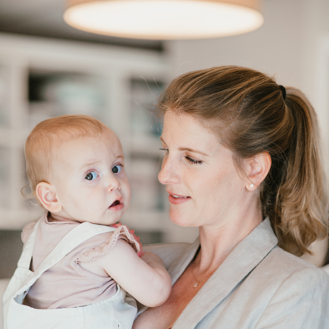 Vrouw houdt baby vast op kinderopvang