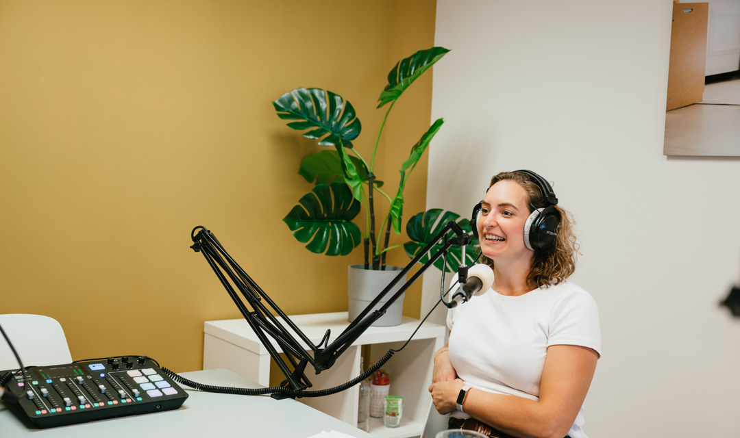 vrouw spreekt in microfoon in podcast ruimte