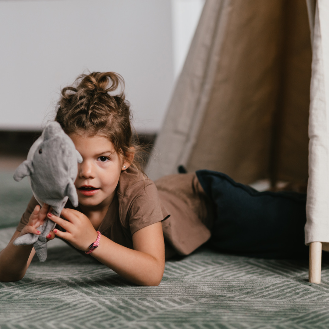 Meisje speelt met knuffel in tipi