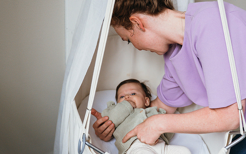 Vrouw legt baby in bed