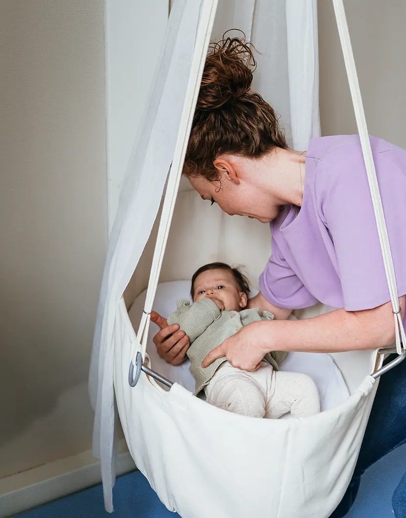 Vrouw legt baby in bed