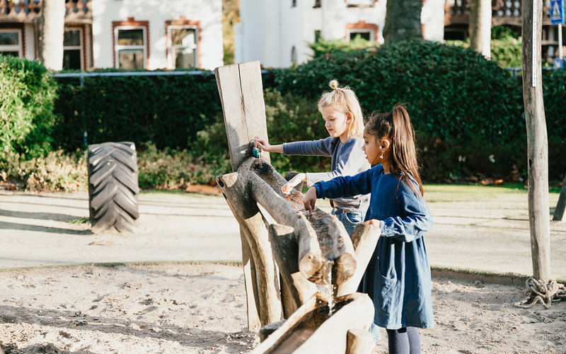 Twee meisjes spelen in zandbak van kinderopvang