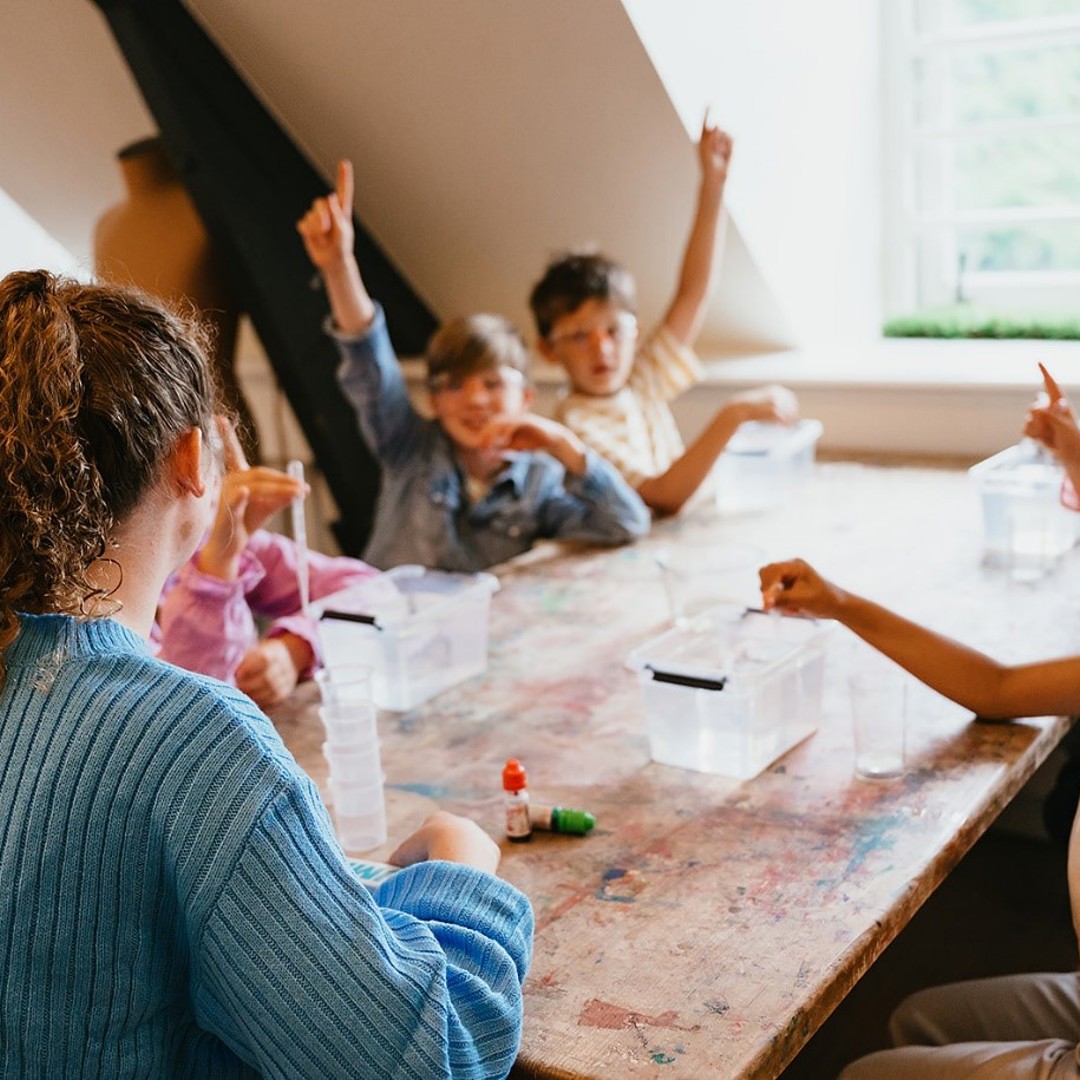 Groep kinderen steekt vinger in de lucht 
