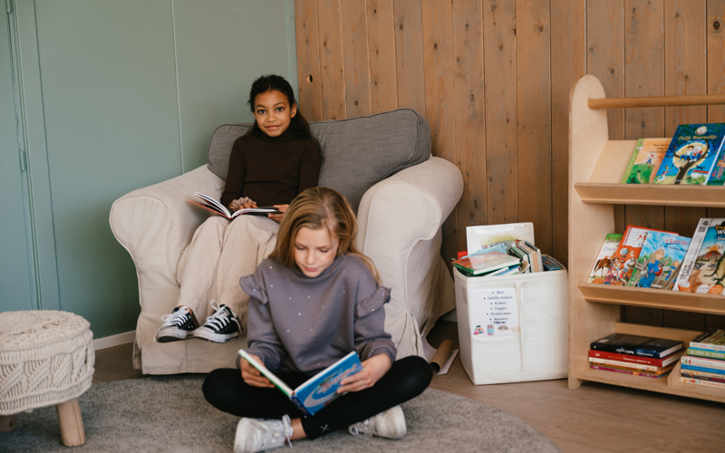 Twee meisjes lezen een boek op de BSO