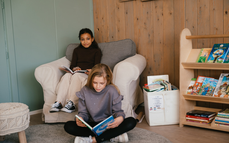 Twee meisjes lezen een boek op de BSO