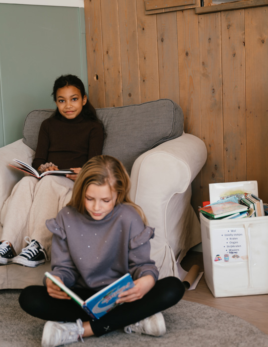 Twee meisjes lezen een boek op de BSO