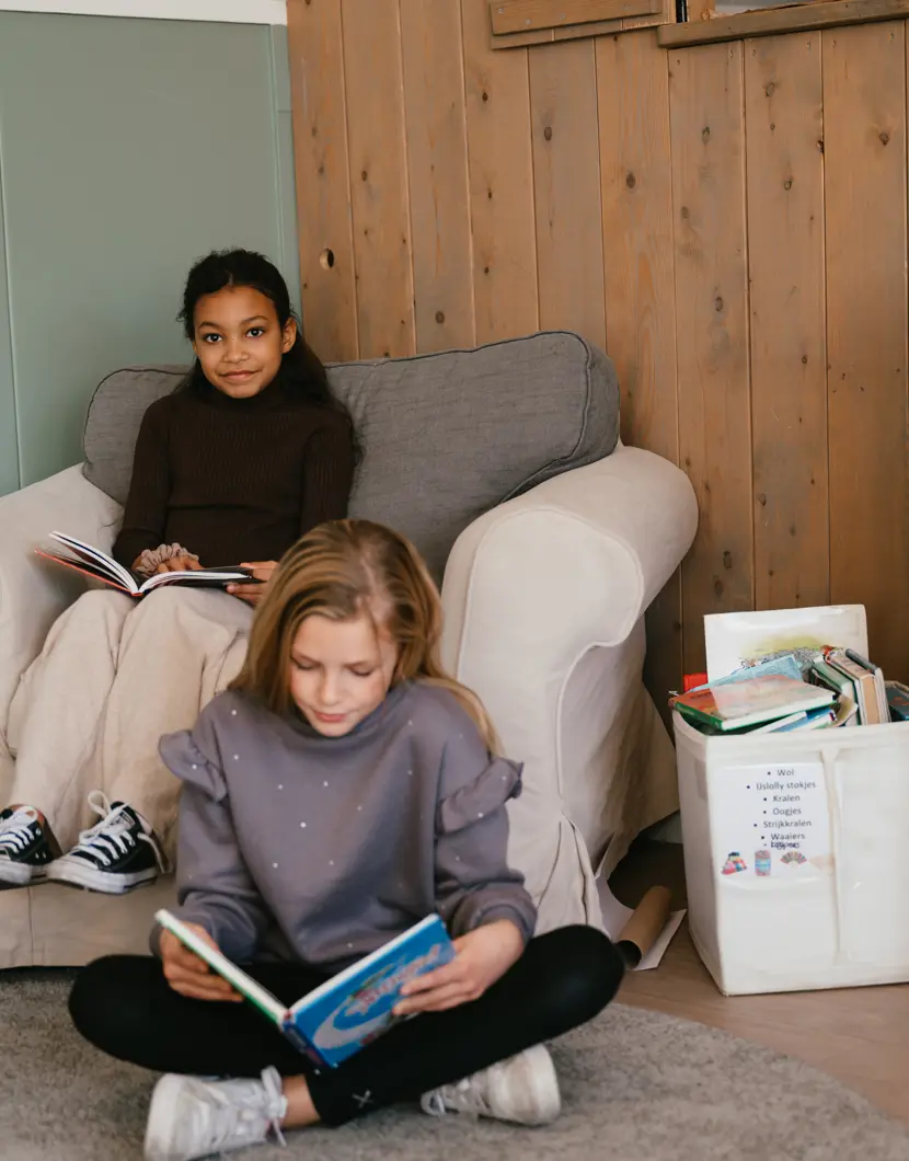 Twee meisjes lezen een boek op de BSO