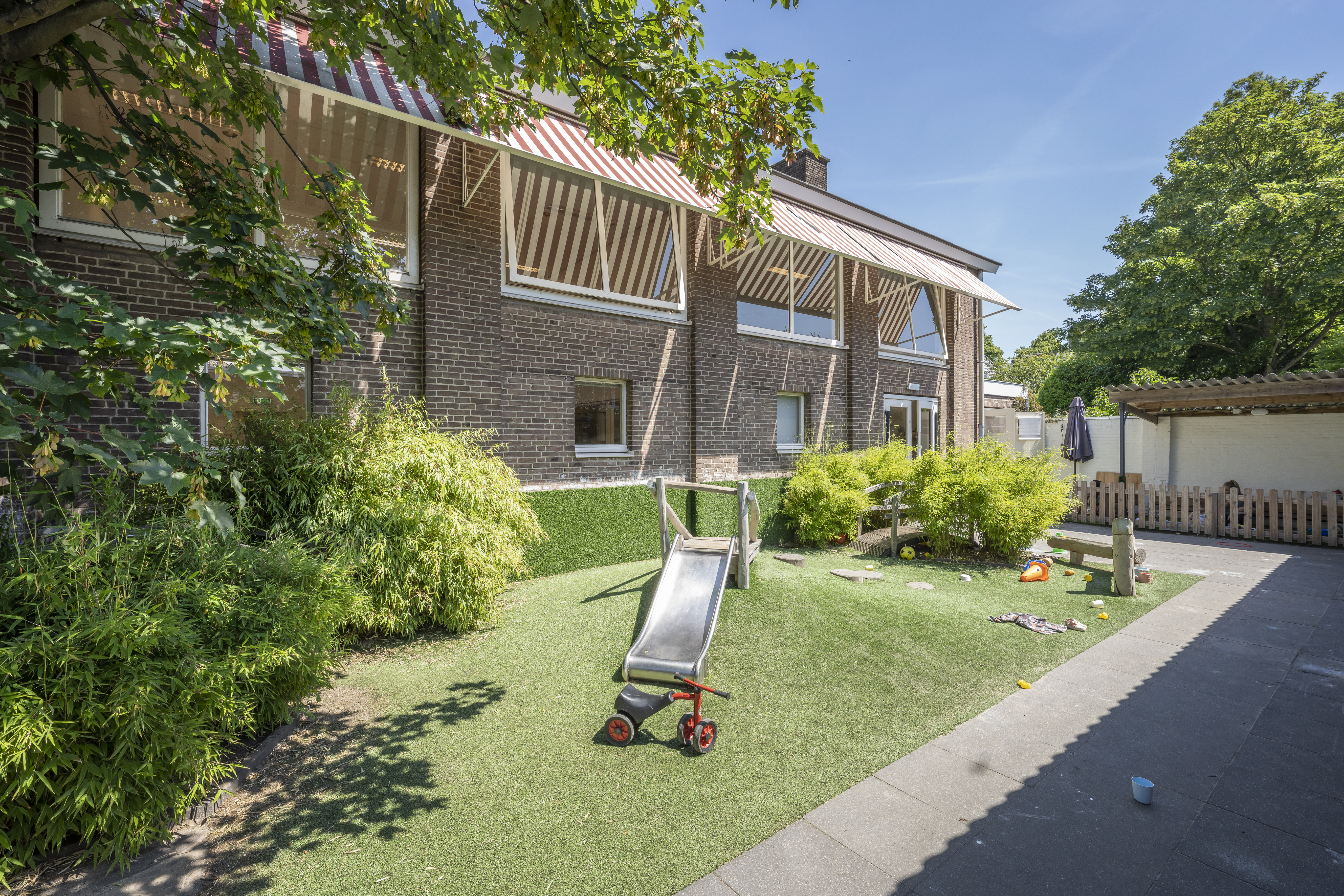 Tuin met glijbaan kinderopvang CompaNanny Kleverpark Haarlem