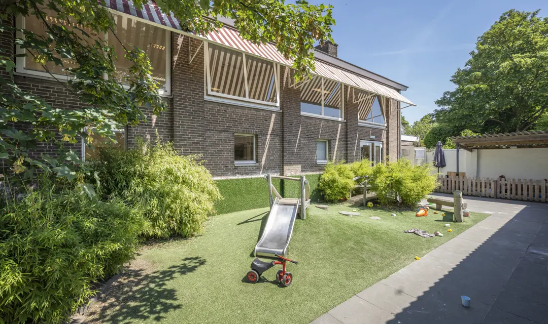 Tuin met glijbaan kinderopvang CompaNanny Kleverpark Haarlem