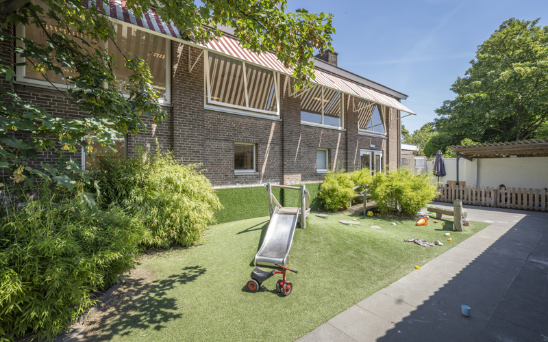 Tuin met glijbaan kinderopvang CompaNanny Kleverpark Haarlem