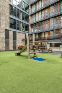 Tuin met gras en speelmaterialen CompaNanny Prinsenhof Den Haag