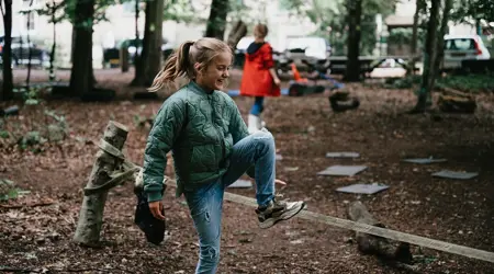 Meisje speelt buiten in een grote tuin en lacht