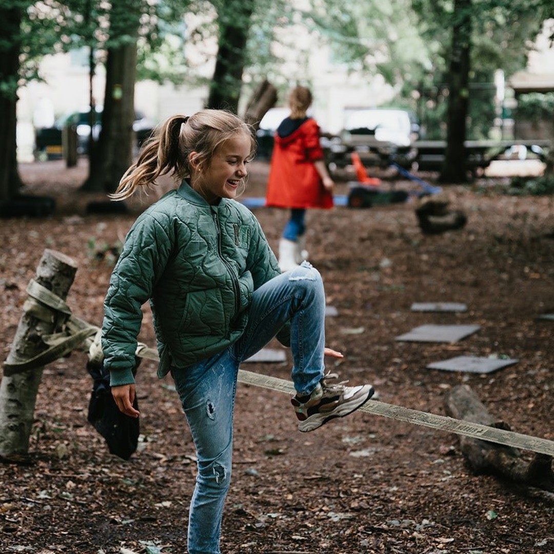 Meisje speelt buiten in een grote tuin en lacht