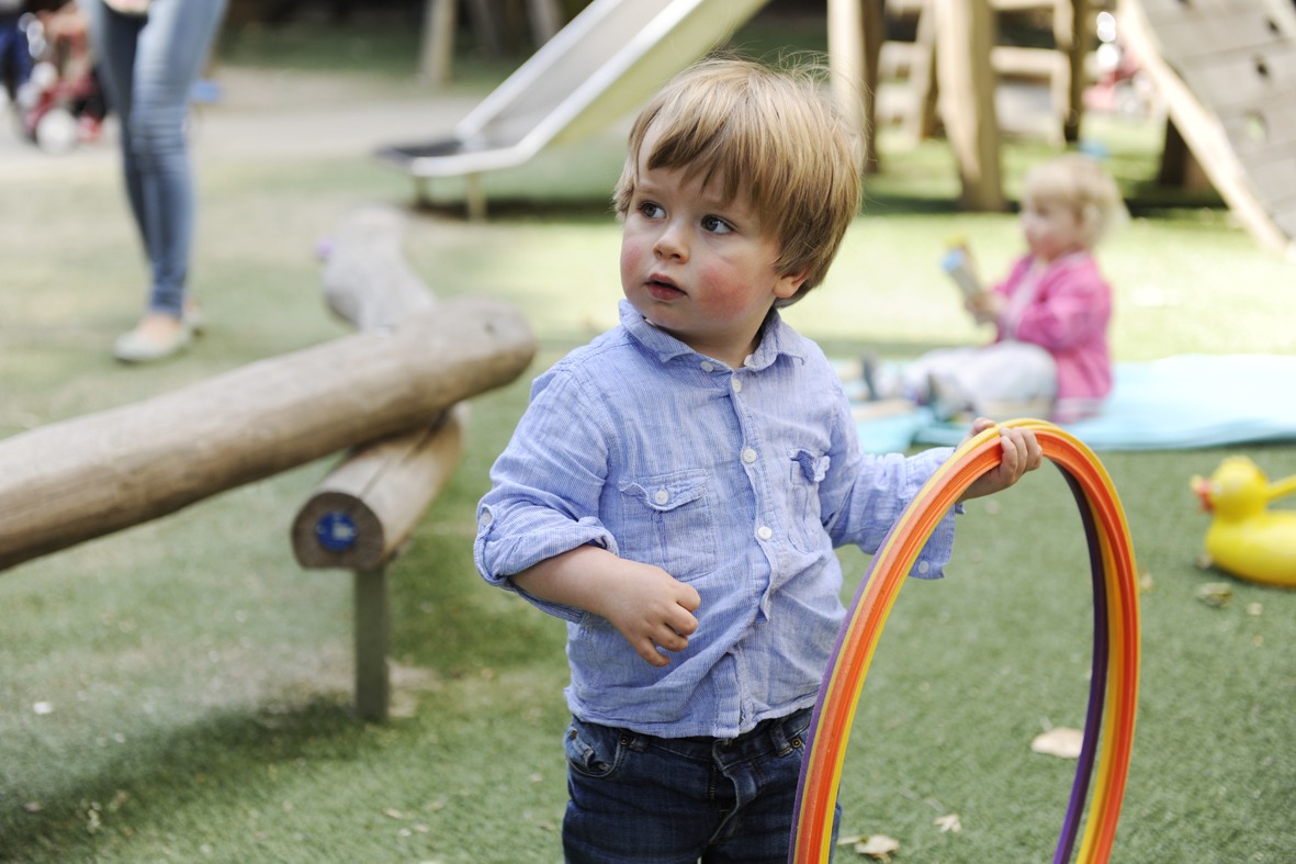 kind speelt met hoepels buiten