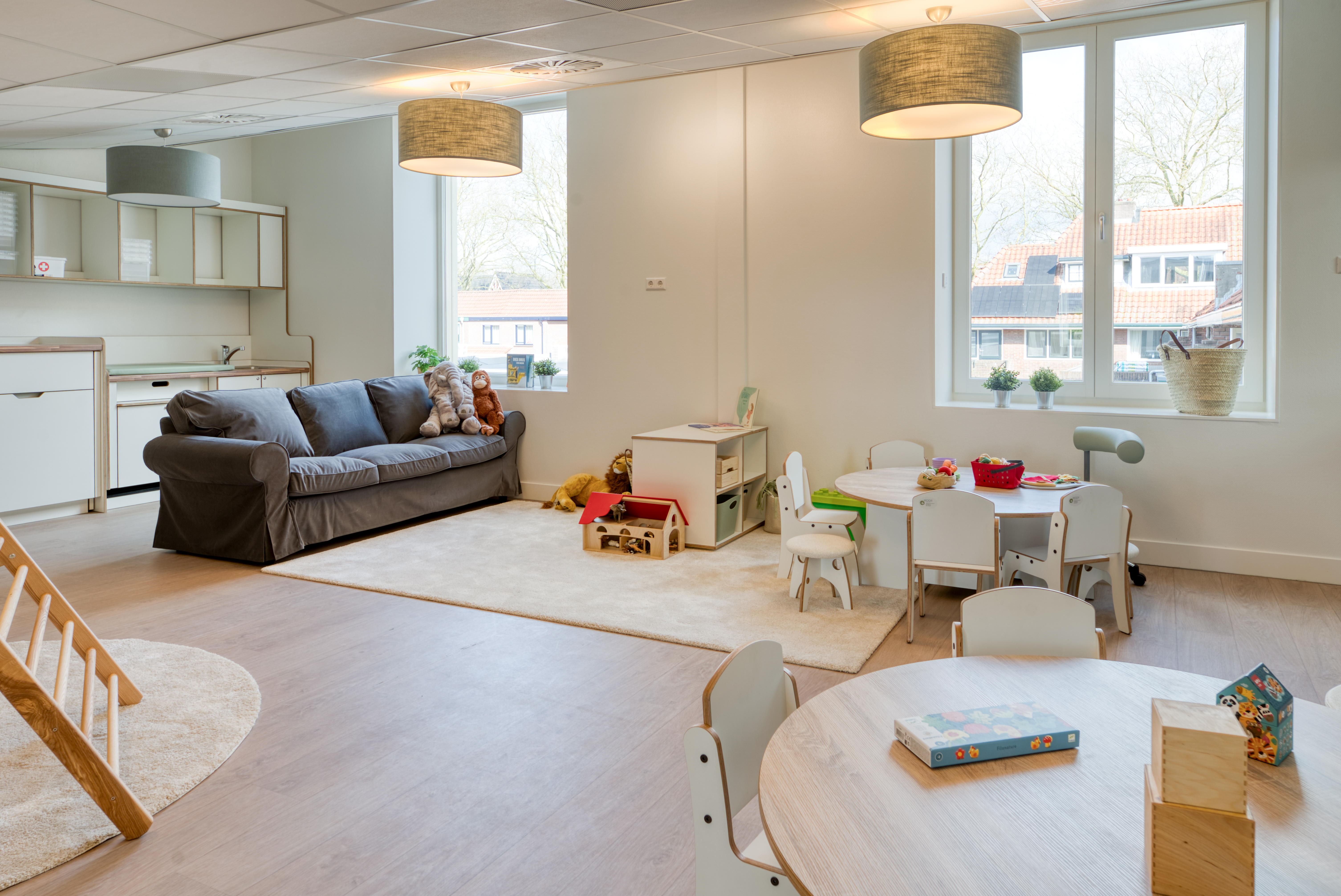 peutergroep inrichting met bank klimdriehoek kleine tafel en stoelen spelmaterialen