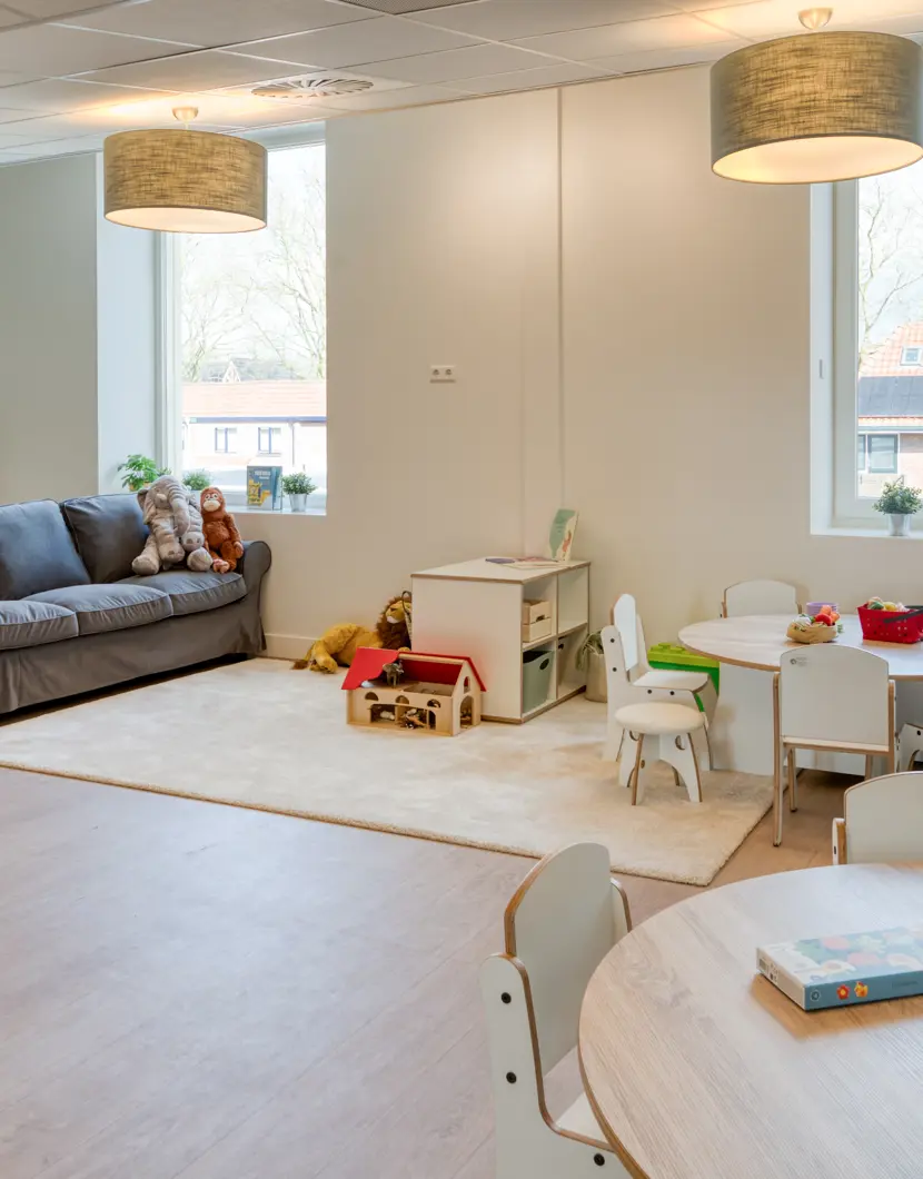 peutergroep inrichting met bank klimdriehoek kleine tafel en stoelen spelmaterialen
