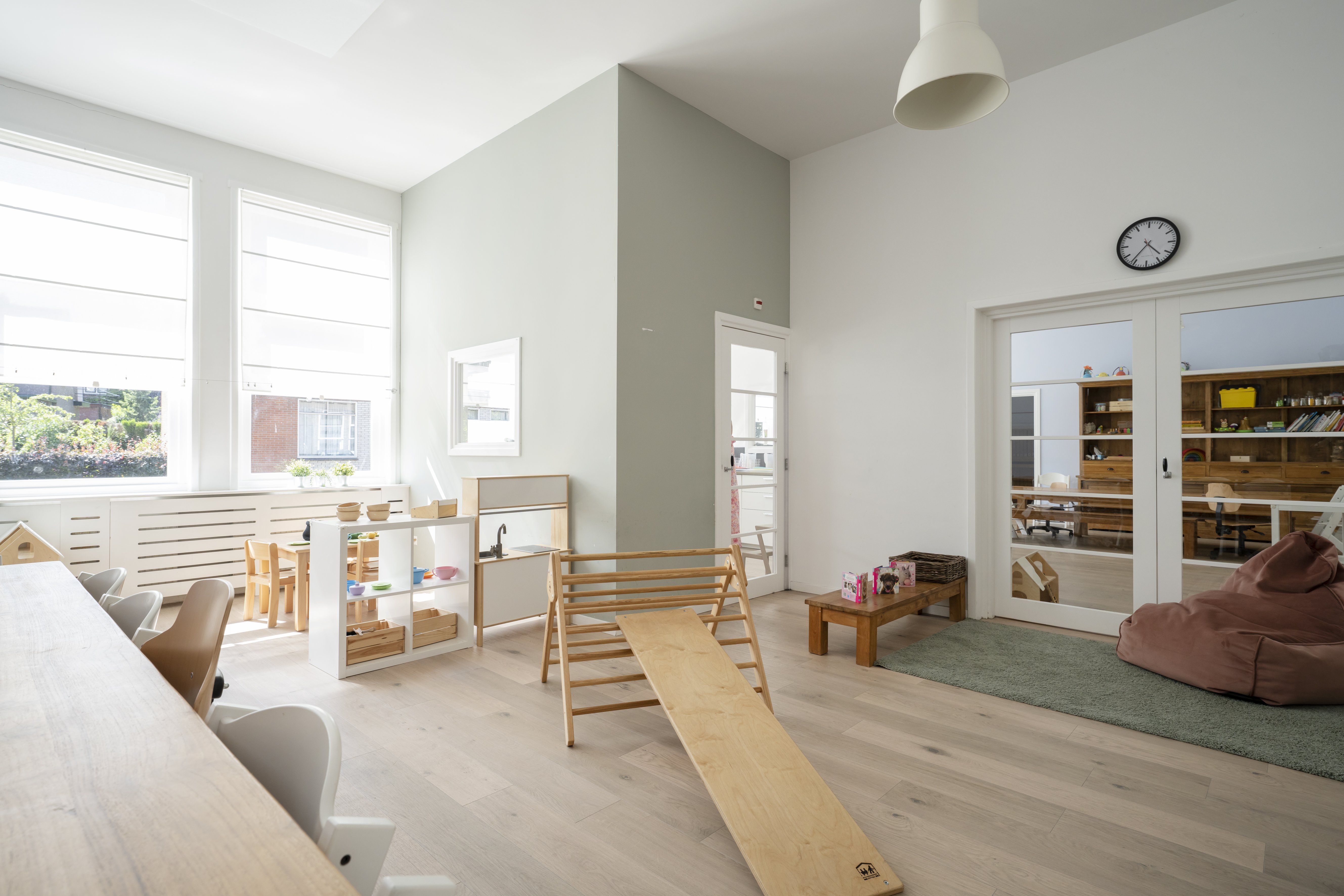 groep kinderopvang met klimdriehoek en houten spelmaterialen