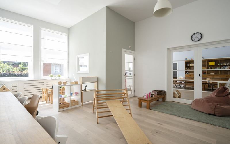 groep kinderopvang met klimdriehoek en houten spelmaterialen
