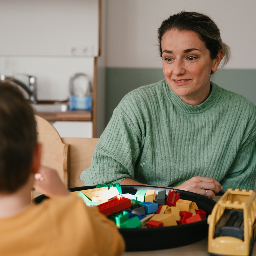 Vrouw praat en speelt met kind