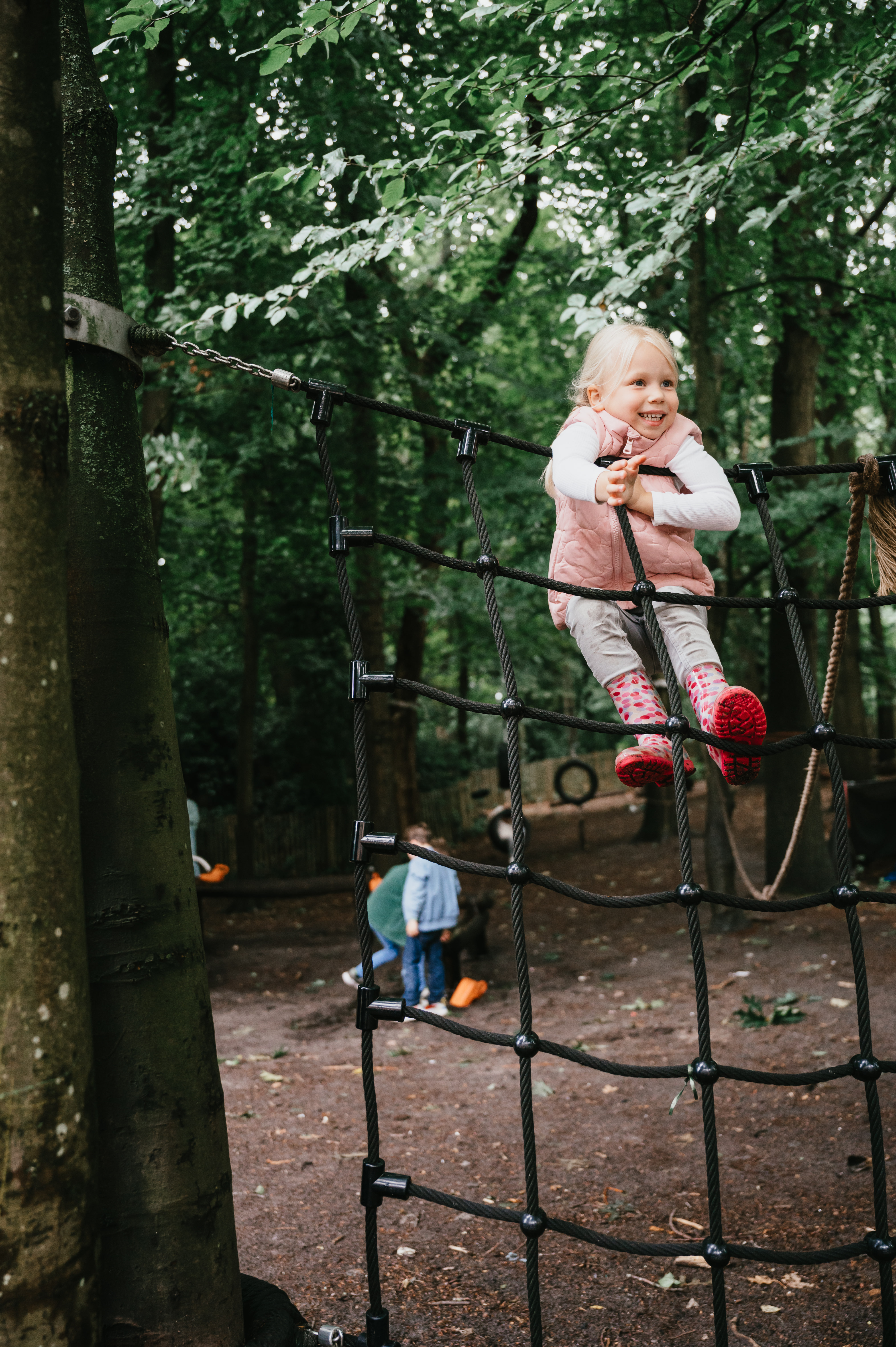 Meisje speelt op klimrek in tuin kinderopvang compananny
