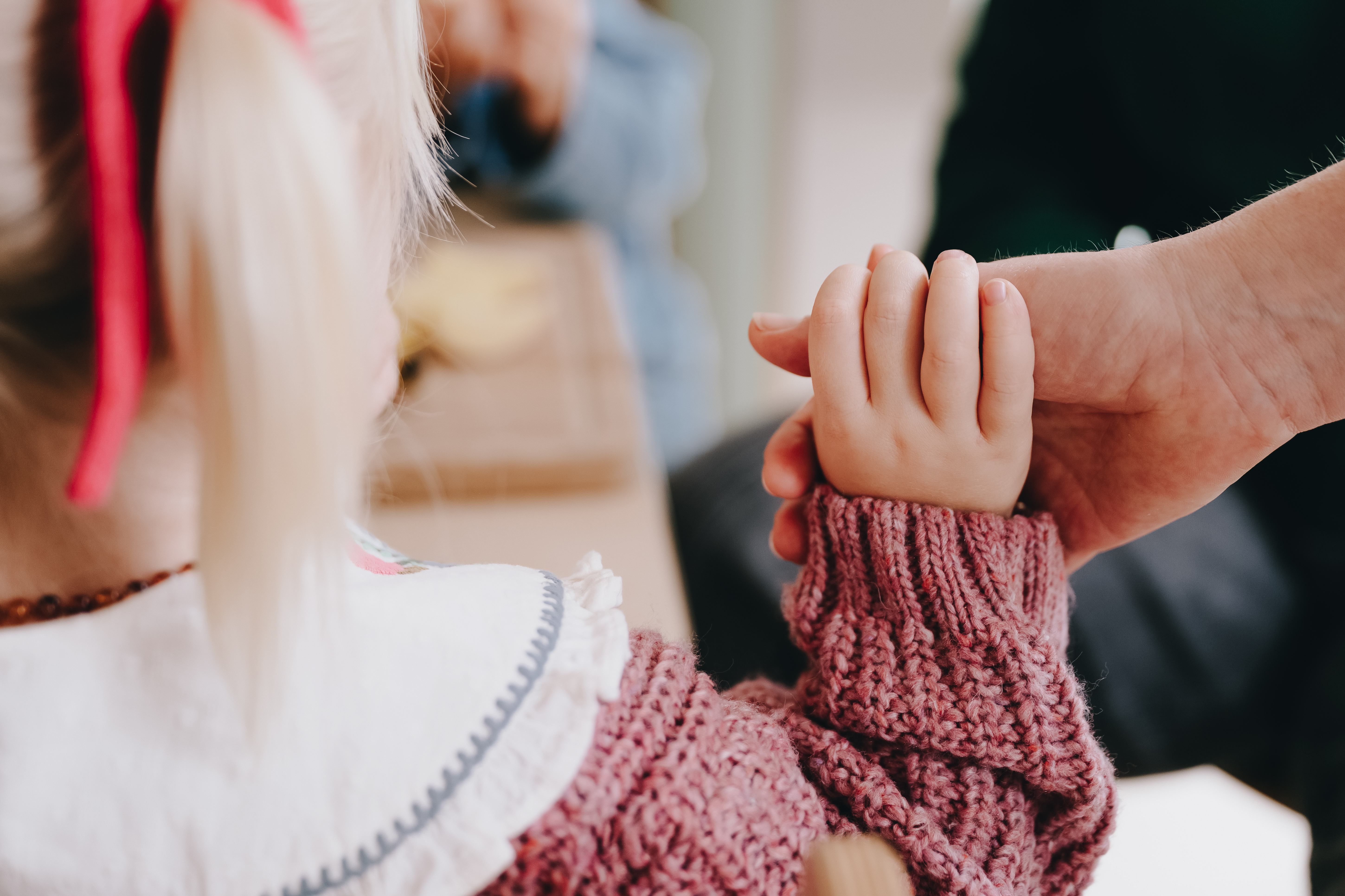 Pedagogisch Professional houdt hand kind vast op kinderopvang CompaNanny