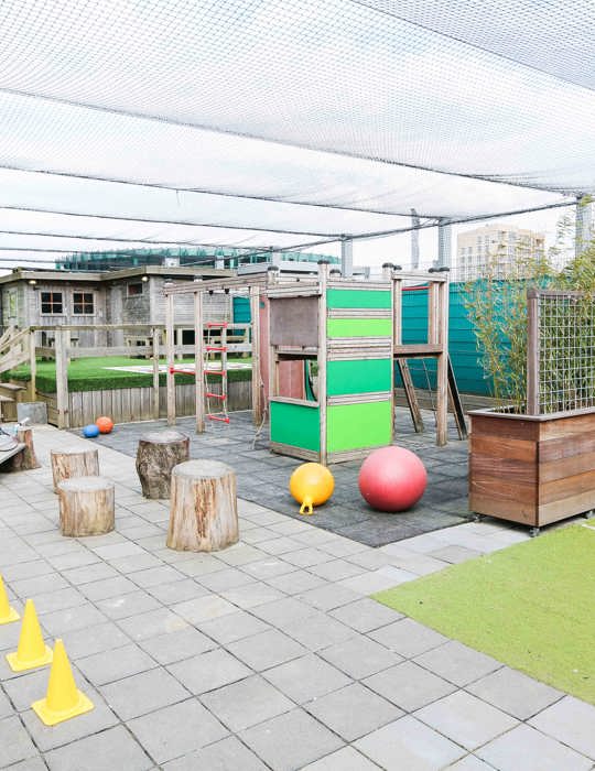 buiten speelruimte van kinderopvang met speeltoestel en voetbalveld