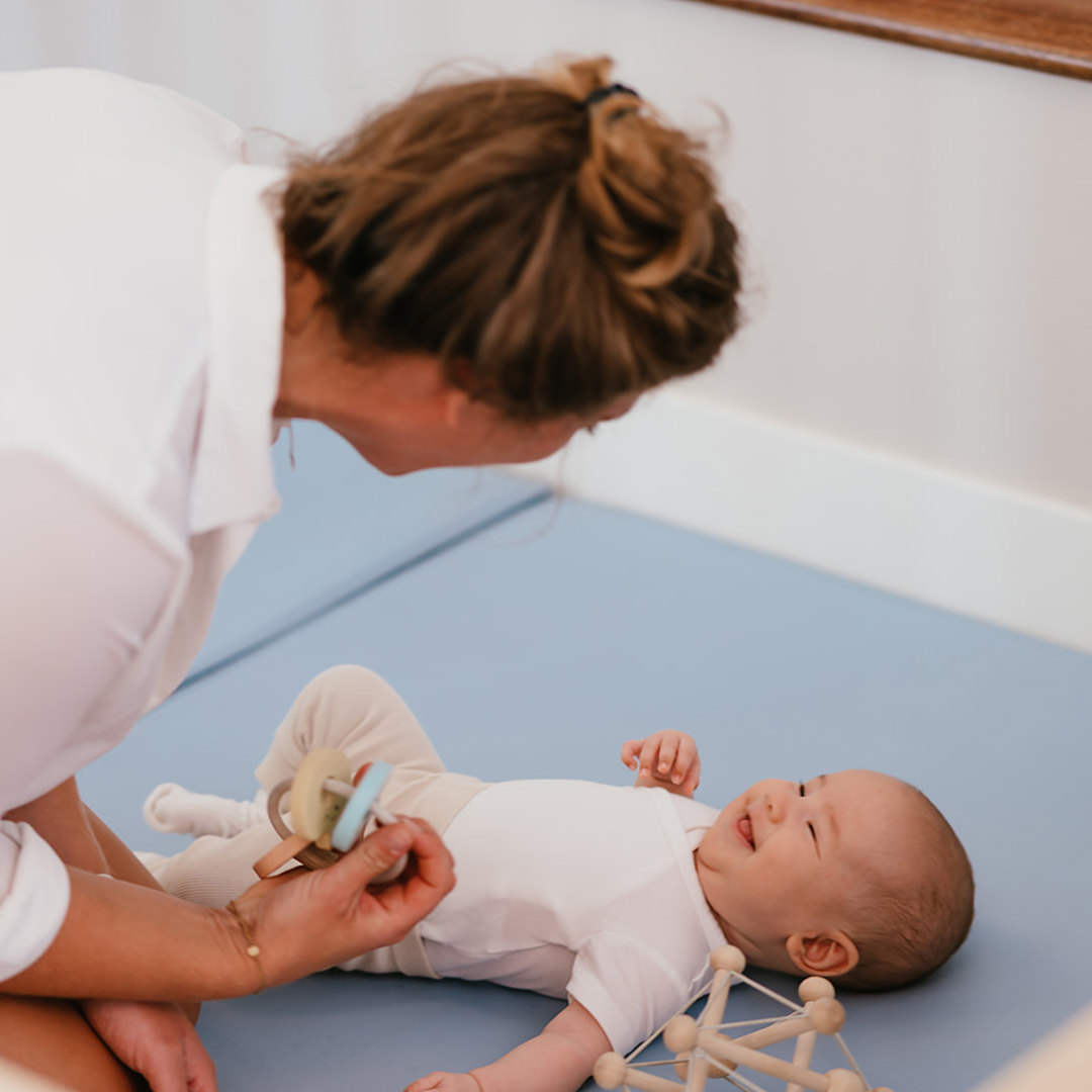 Baby lacht naar Pedagogisch Medewerker