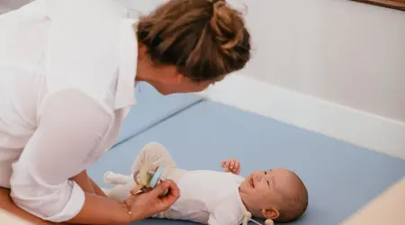 Baby lacht naar Pedagogisch Medewerker
