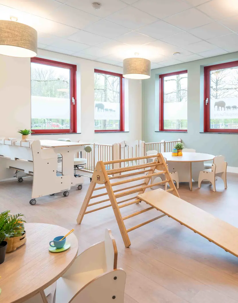 babygroep inrichting met houten meubels grondbox en klimdriehoek