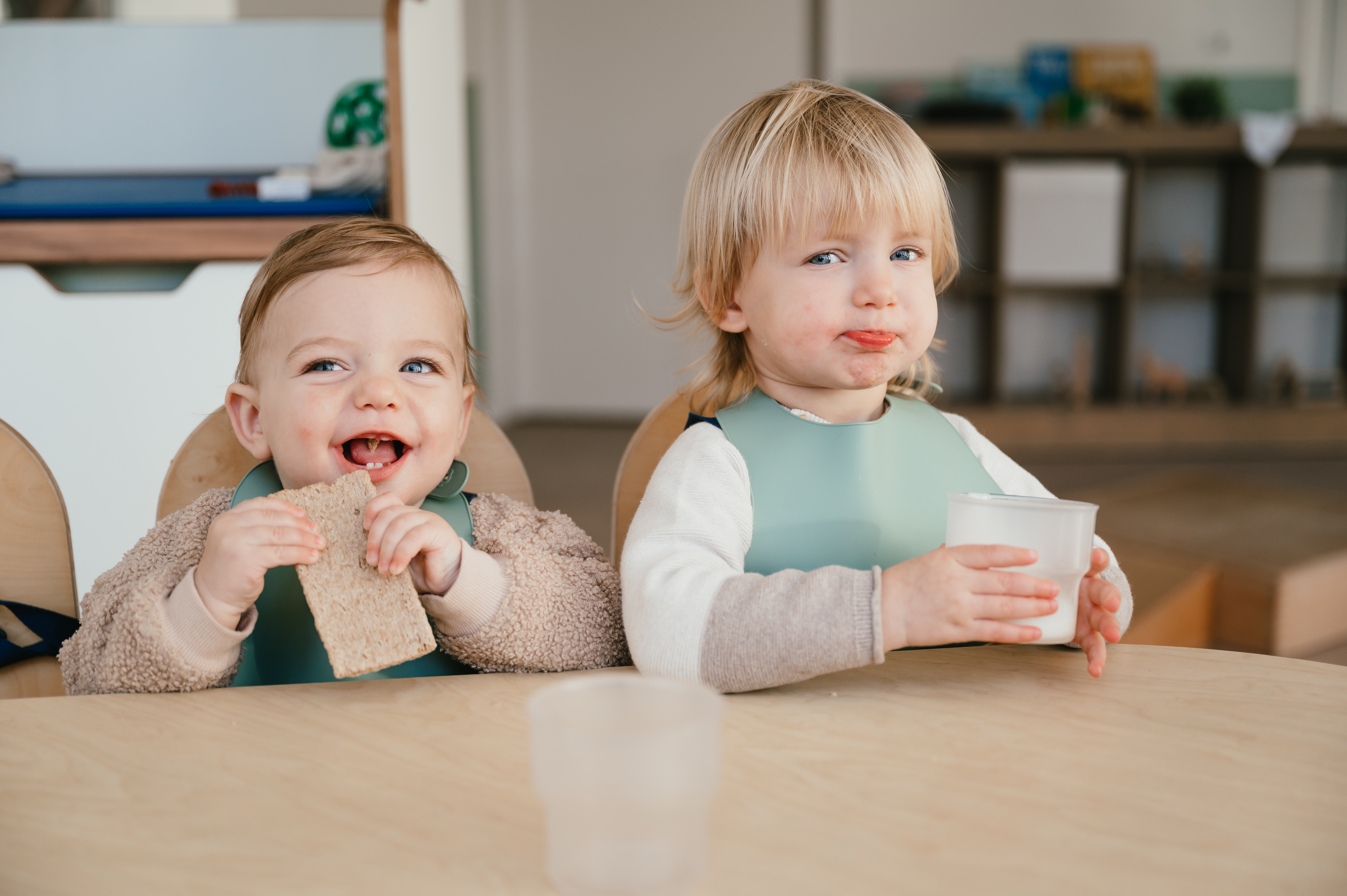 Dreumesen eten en drinken aan tafel op kinderopvang