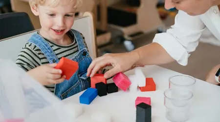 Jongen speelt met vrouw op kinderopvang