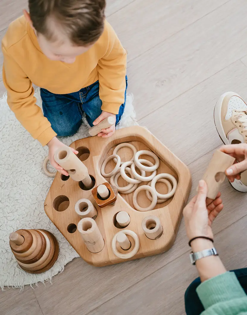 Peuter speelt met houten speelgoed op kinderopvang