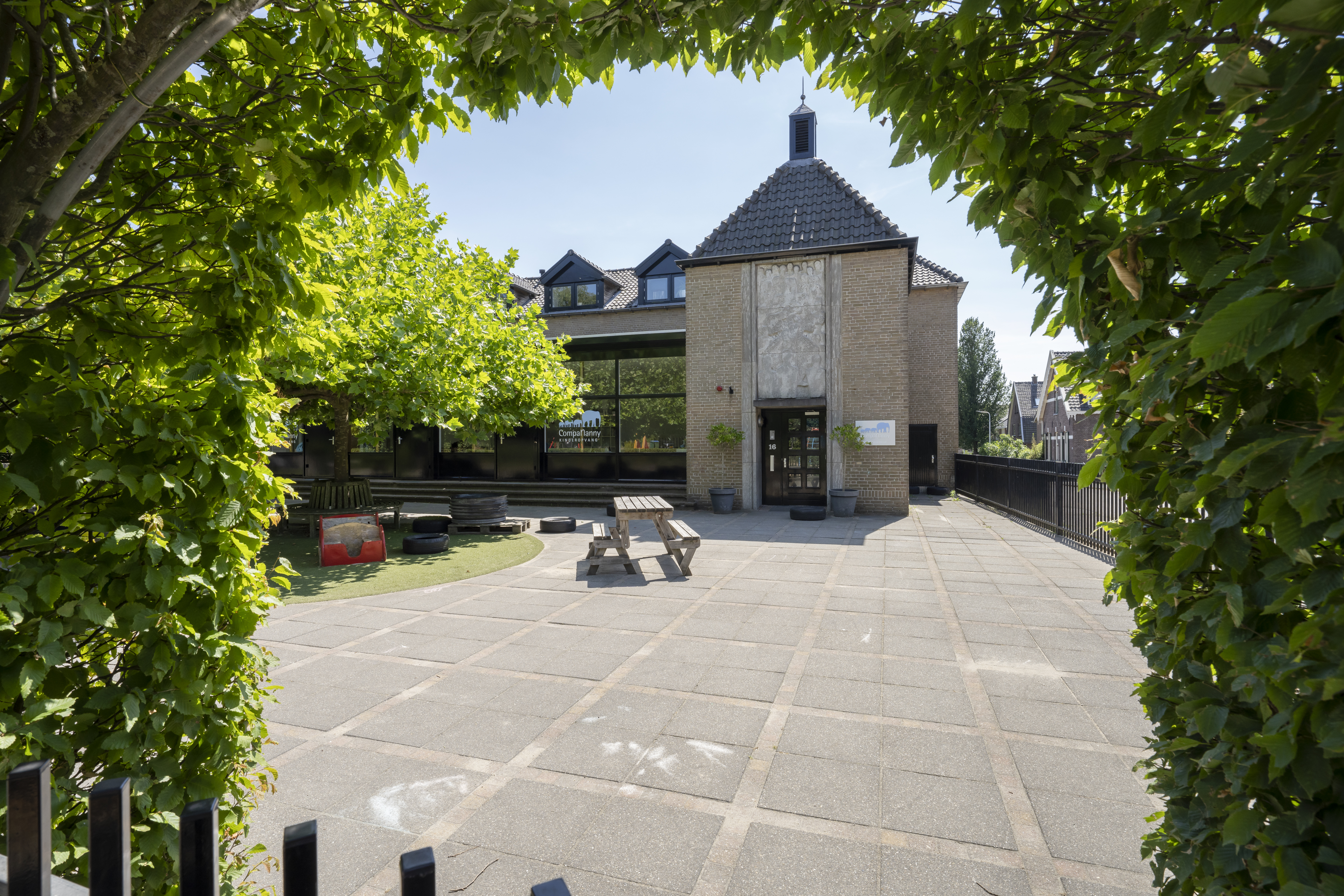 voorkant kinderopvang gebouw en buiten speelplaats