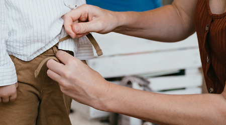 Vrouw doet broek aan bij peuter