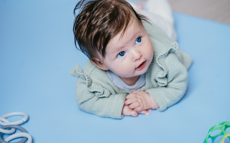 baby ligt op grondbox en kijkt omhoog