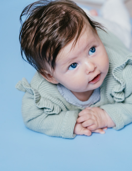 baby ligt op grondbox en kijkt omhoog