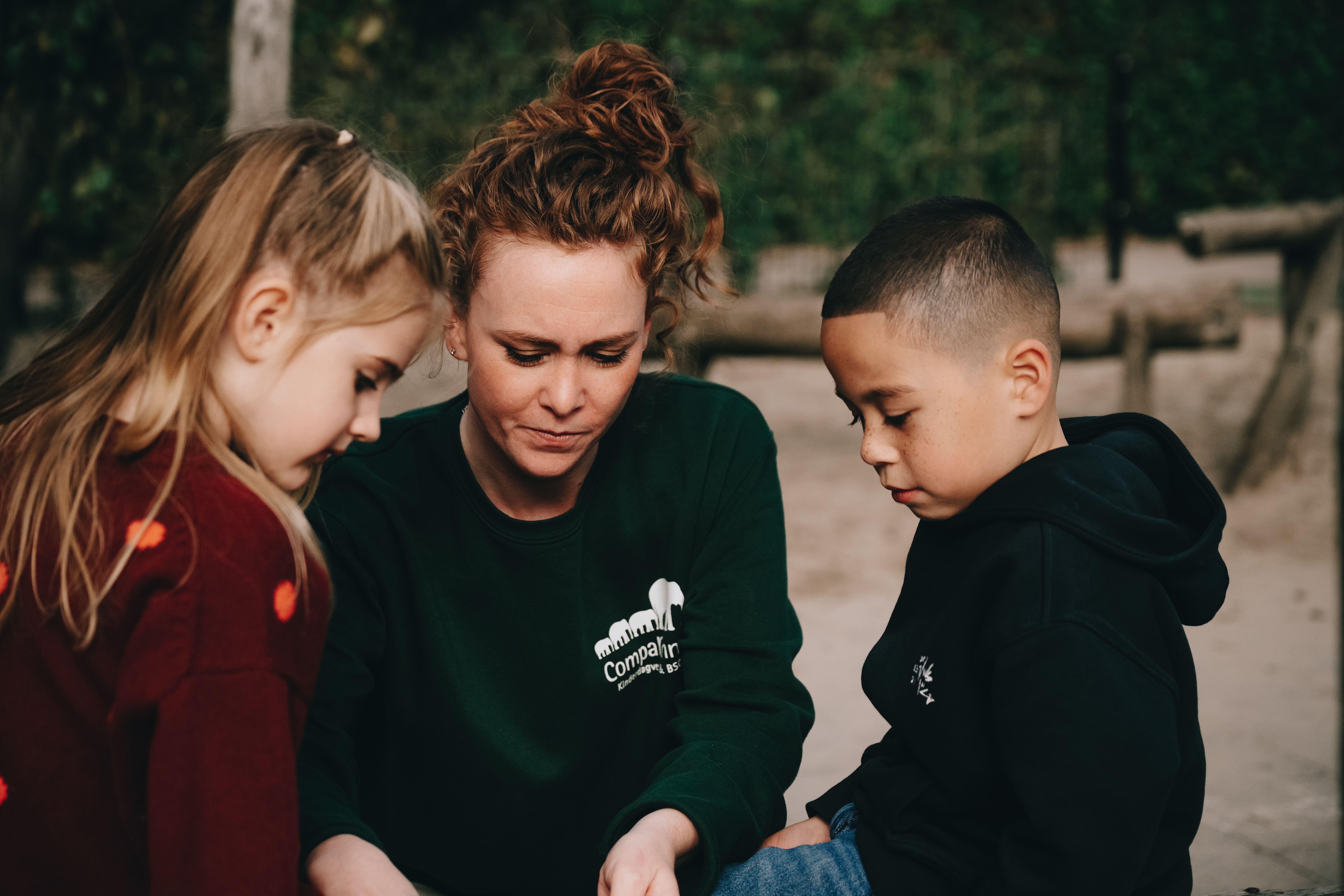pedagogisch professional buiten met twee kinderen