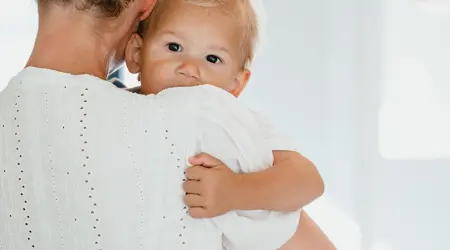 Pedagogisch Medewerker houdt baby vast