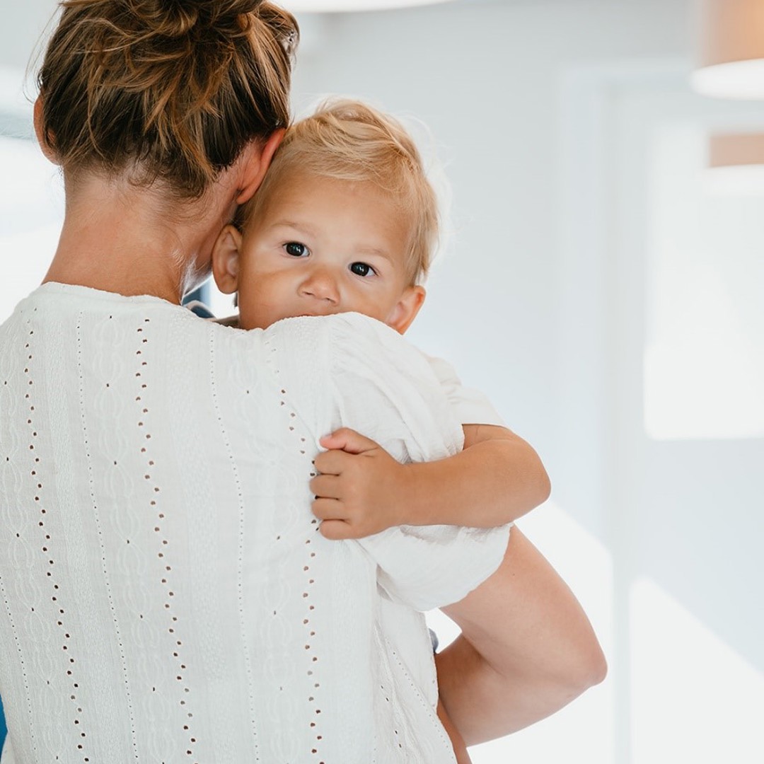 Pedagogisch Medewerker houdt baby vast