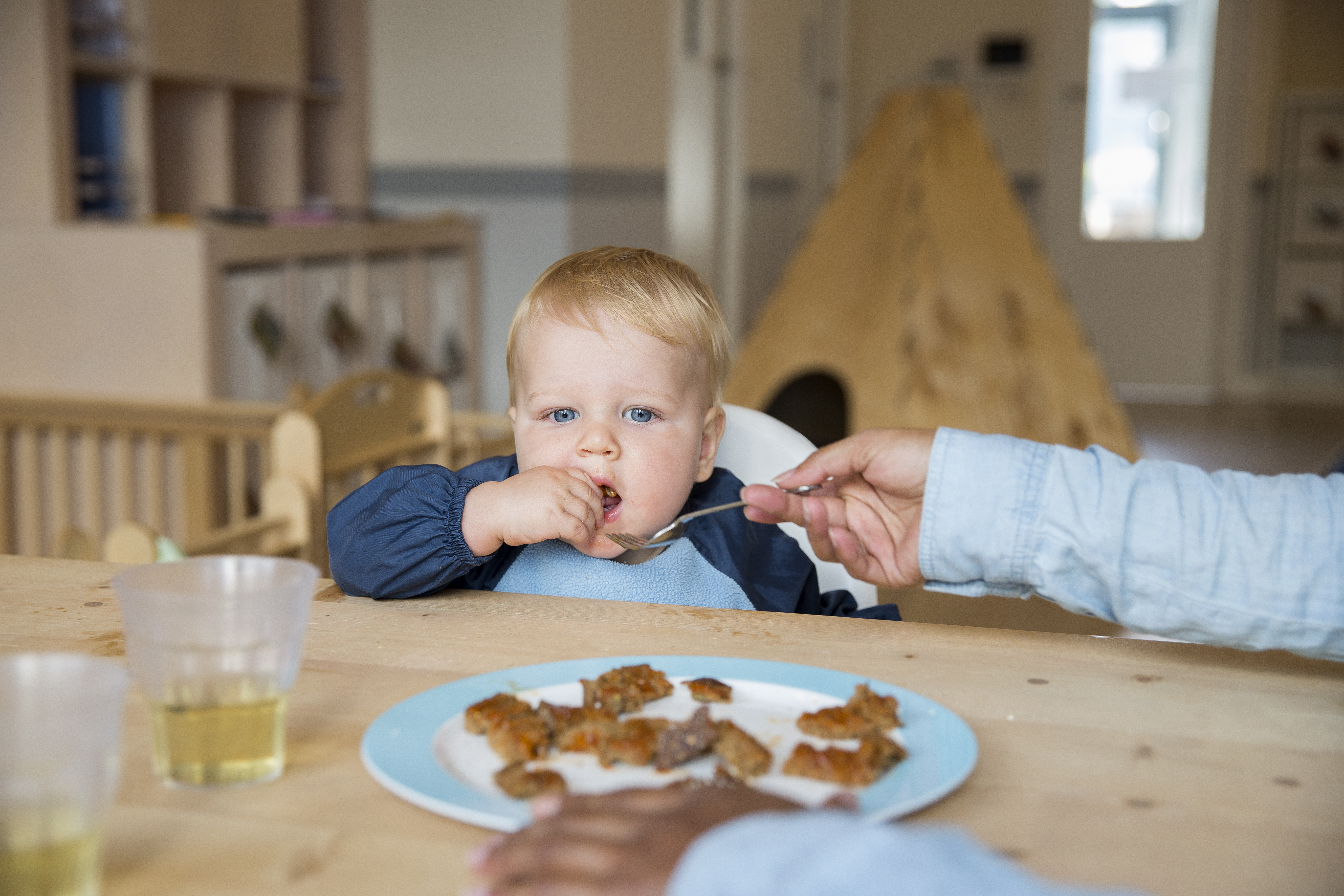 kind wordt gevoerd door pedagogisch medewerker