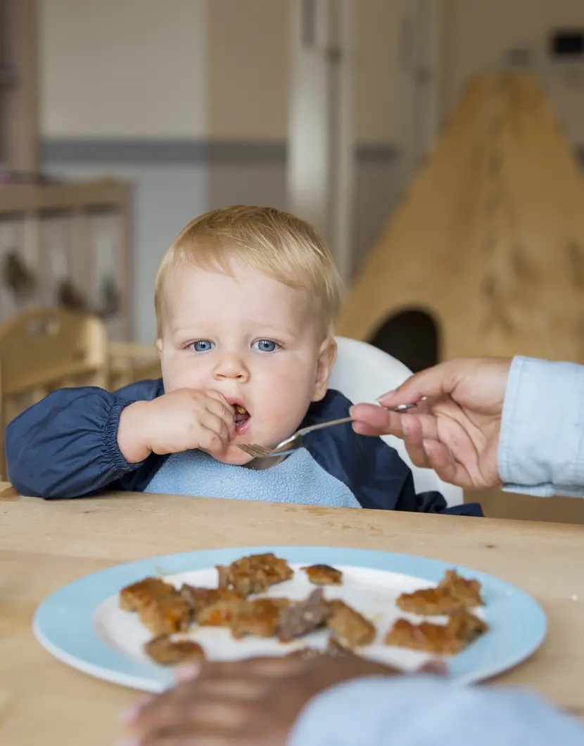 kind wordt gevoerd door pedagogisch medewerker