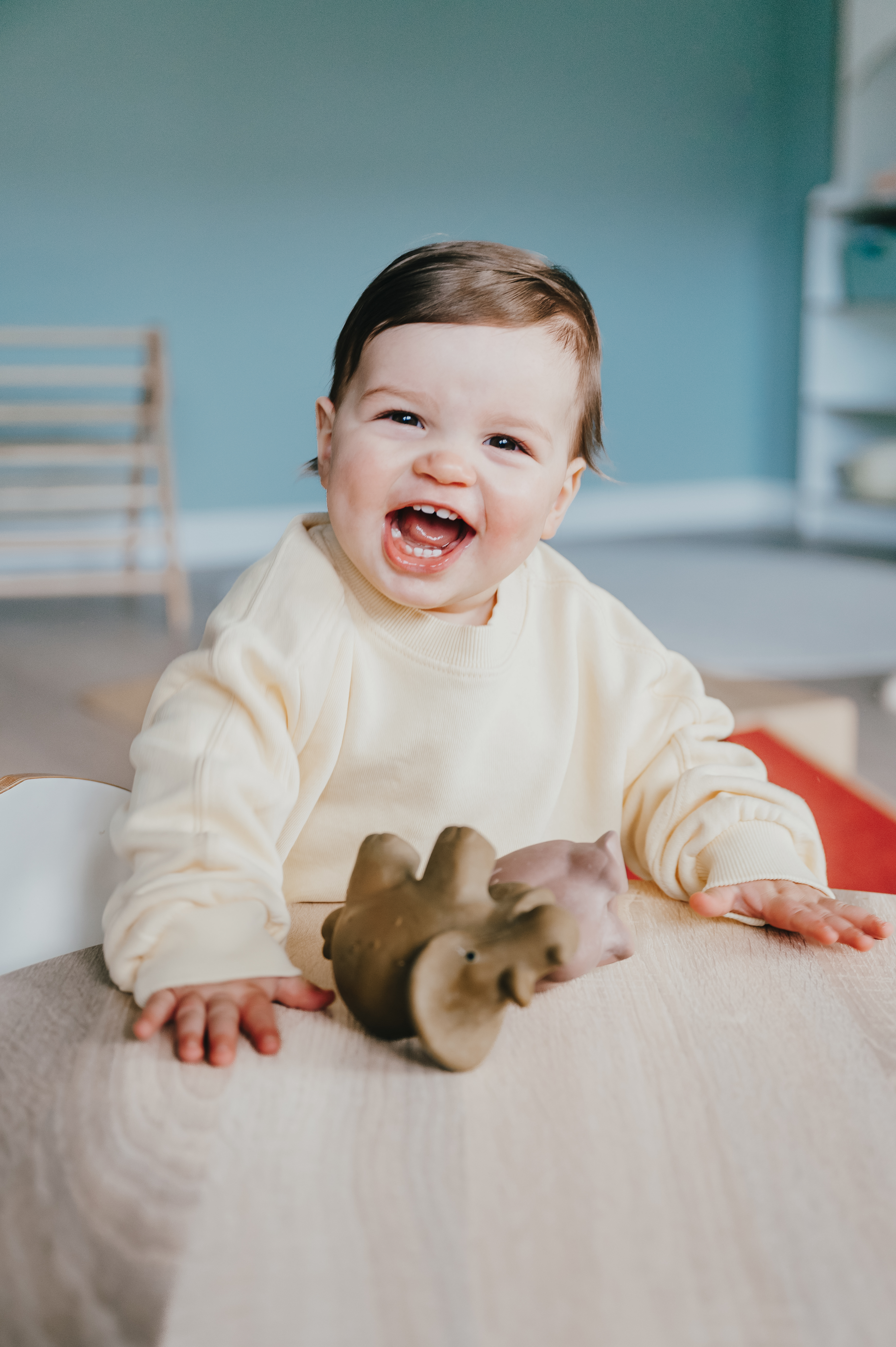 Kind staat aan tafel en lacht heel blij
