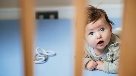 Baby ligt in grondbox